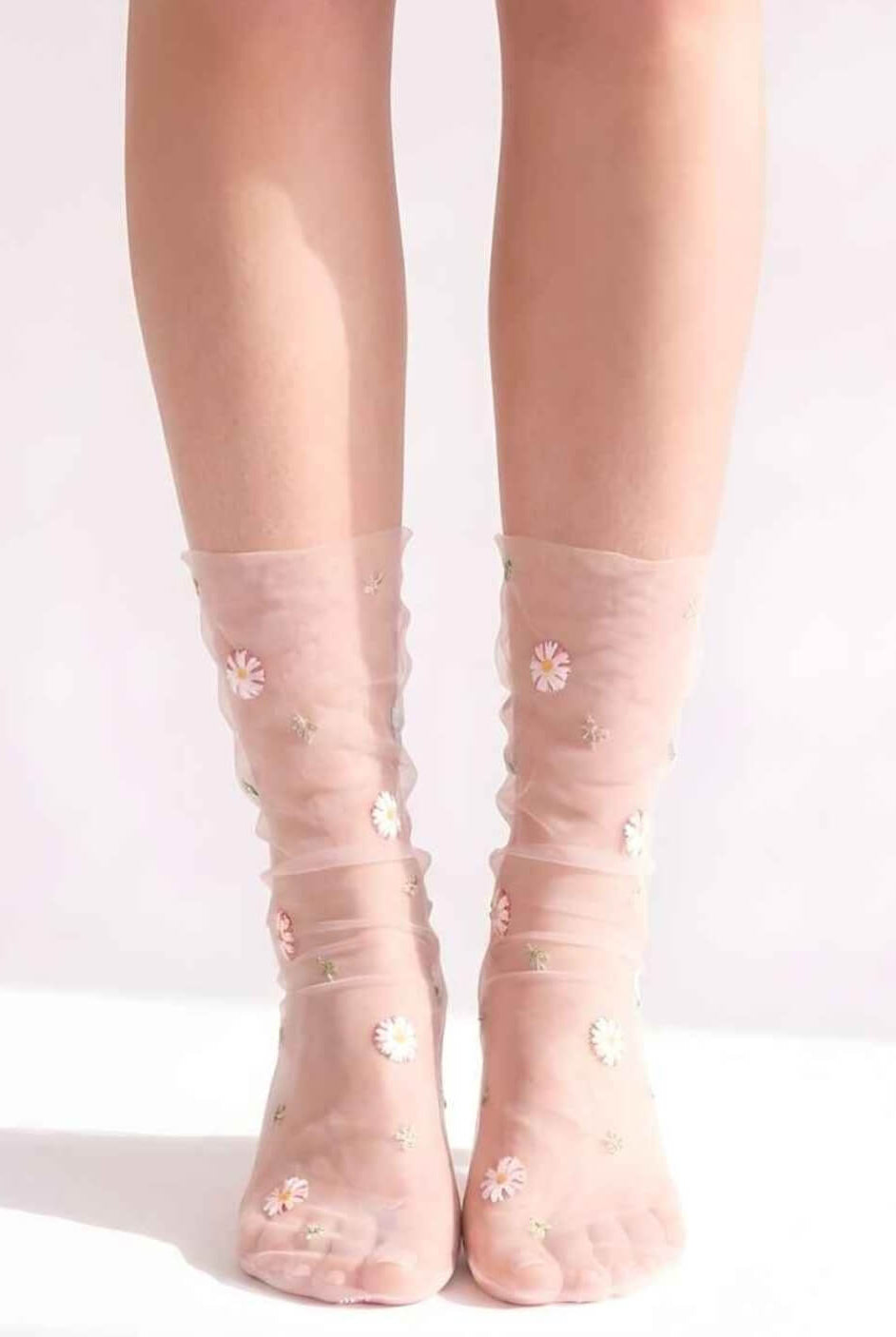 Sheer Garden Daisy Crew Socks in pink sheer fabric with scattered daisy embroidery, front view on both feet to showcase floral detailing and soft texture.