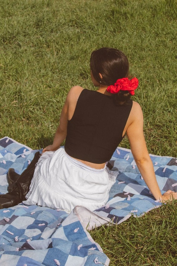 Model styled with the Red Eyelet Jumbo Scrunchie adding volume and texture to a hairstyle with its soft elastic eyelet fabric design.