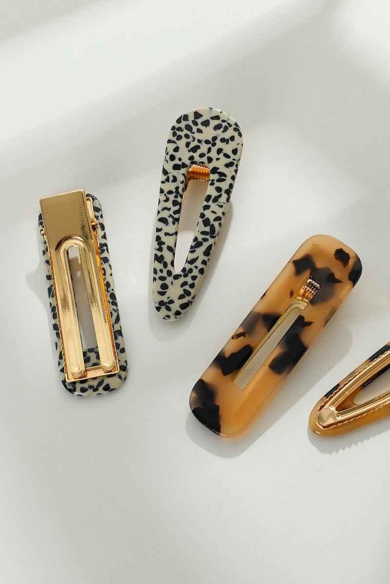 Leopard print and tortoiseshell hair clips with gold accents on a white background, Love Classic style