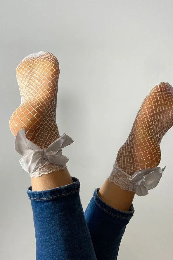 White fishnet socks with lace and satin bows, worn with jeans, Love Classic fashion style