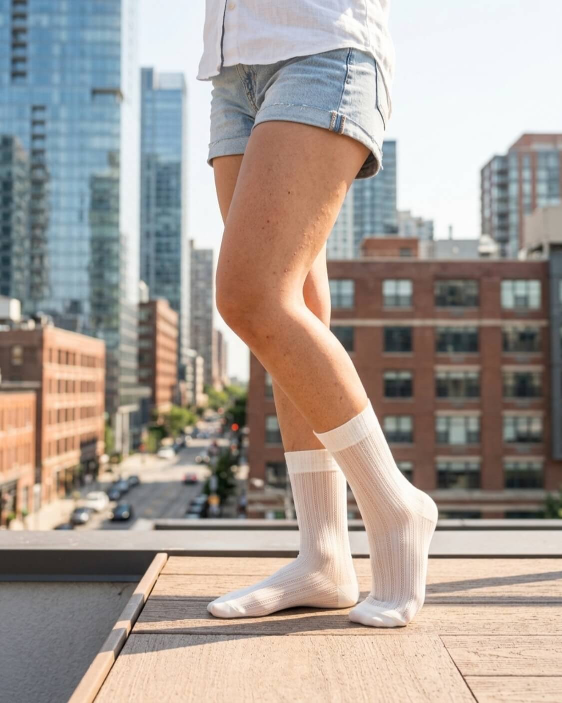 5-Pack Soft Horizon Sheer Socks featuring a sheer ribbed texture and reinforced heel and toe, worn with denim shorts while standing on a rooftop terrace, highlighting breathable comfort and everyday versatility.