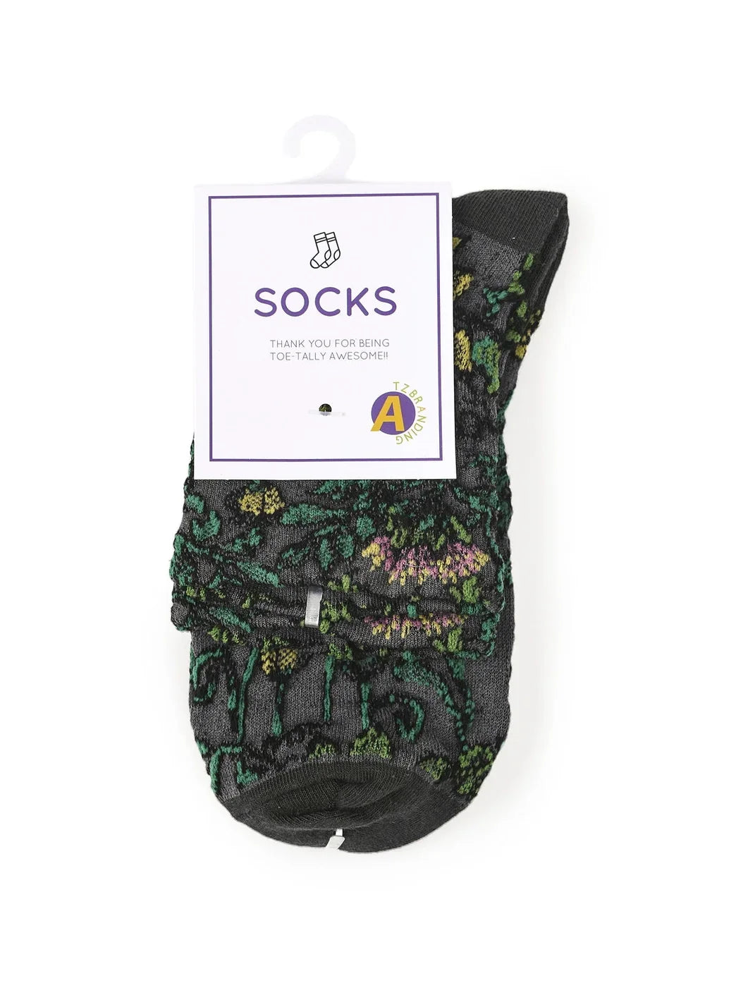 Black floral patterned socks with green and purple details, packaged with a label.