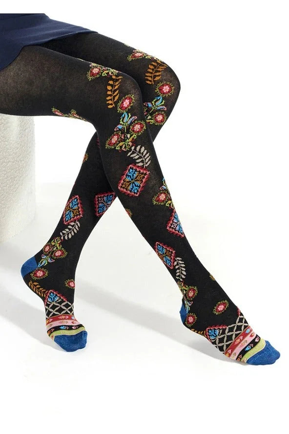 Woman wearing Love Classic black tights with colorful floral and geometric patterns