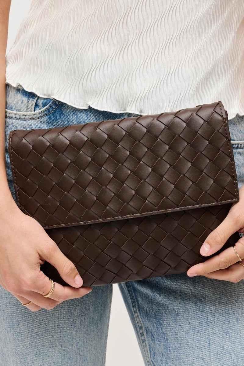 Woman holding woven brown clutch bag, casual style, Love Classic fashion accessory