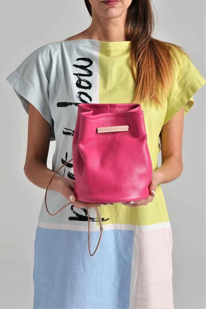 Woman holding a pink leather bucket bag, colorful dress, Love Classic high quality style