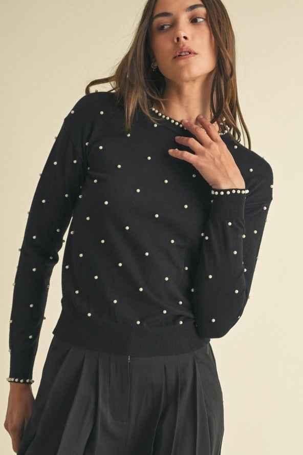 Woman wearing black pearl studded sweater and pleated skirt, Love Classic fashion style