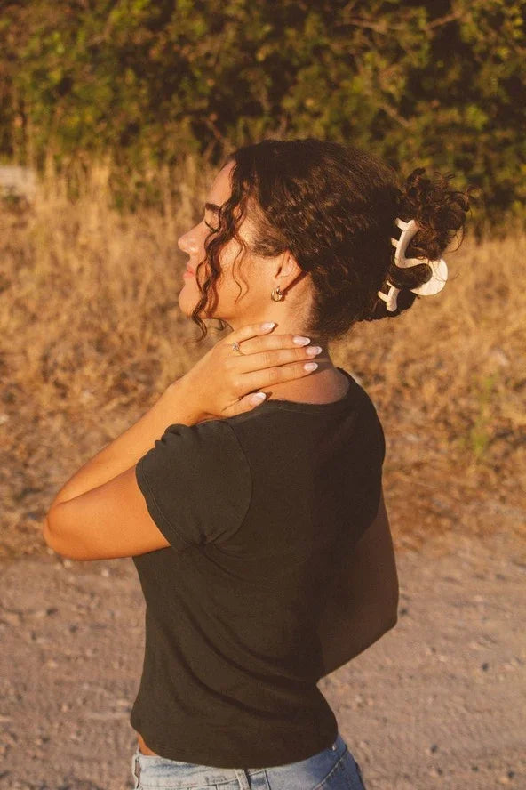 Woman outdoors wearing black top and hair claw, Love Classic style fashion