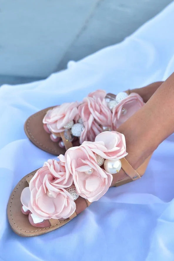 Woman wearing Love Classic sandals with pink flower embellishments and pearl accents