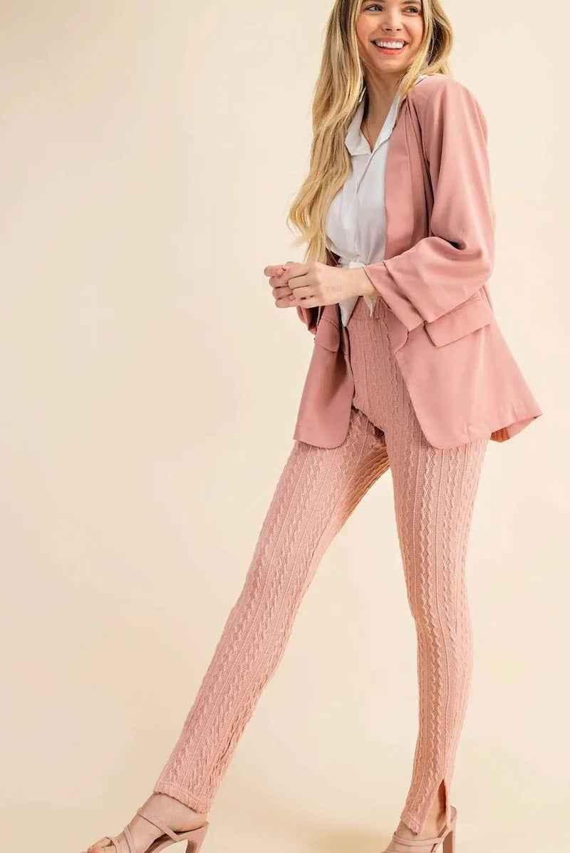 Smiling woman in pink textured leggings, matching blazer, and heels, styled for Love Classic fashion.