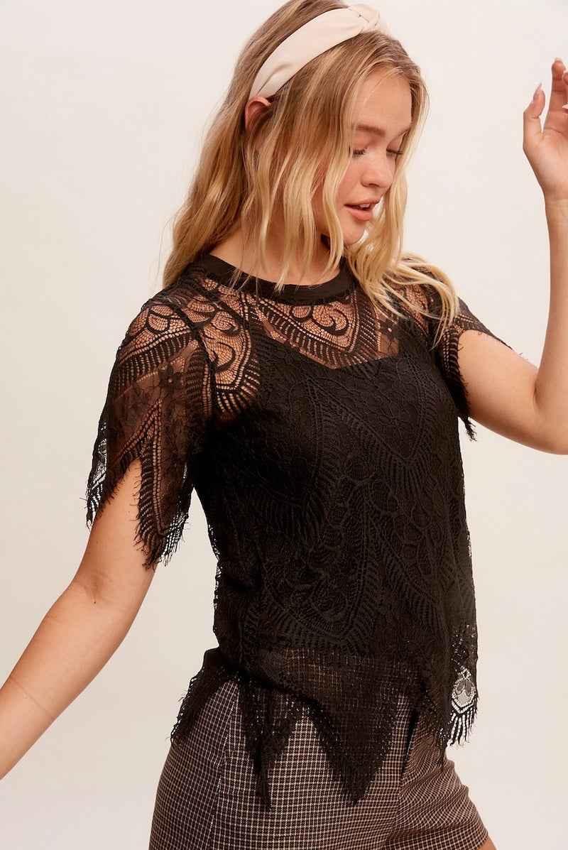 Woman wearing a black lace top from Love Classic, styled with plaid pants and a headband.