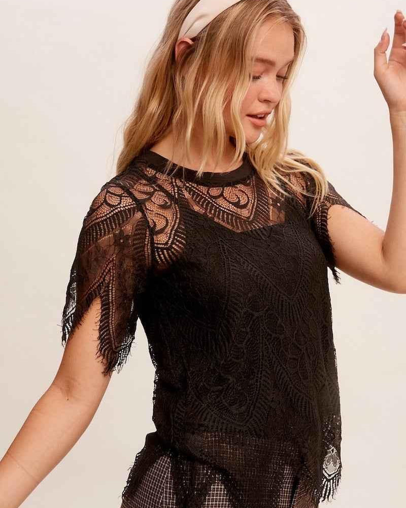 Woman wearing a black lace top from Love Classic, styled with plaid pants and a headband.
