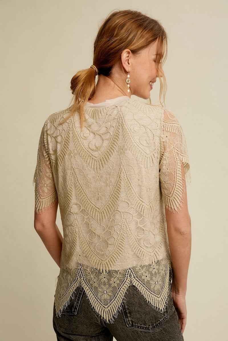 Woman wearing a sheer lace top with floral patterns from Love Classic, shown from the back