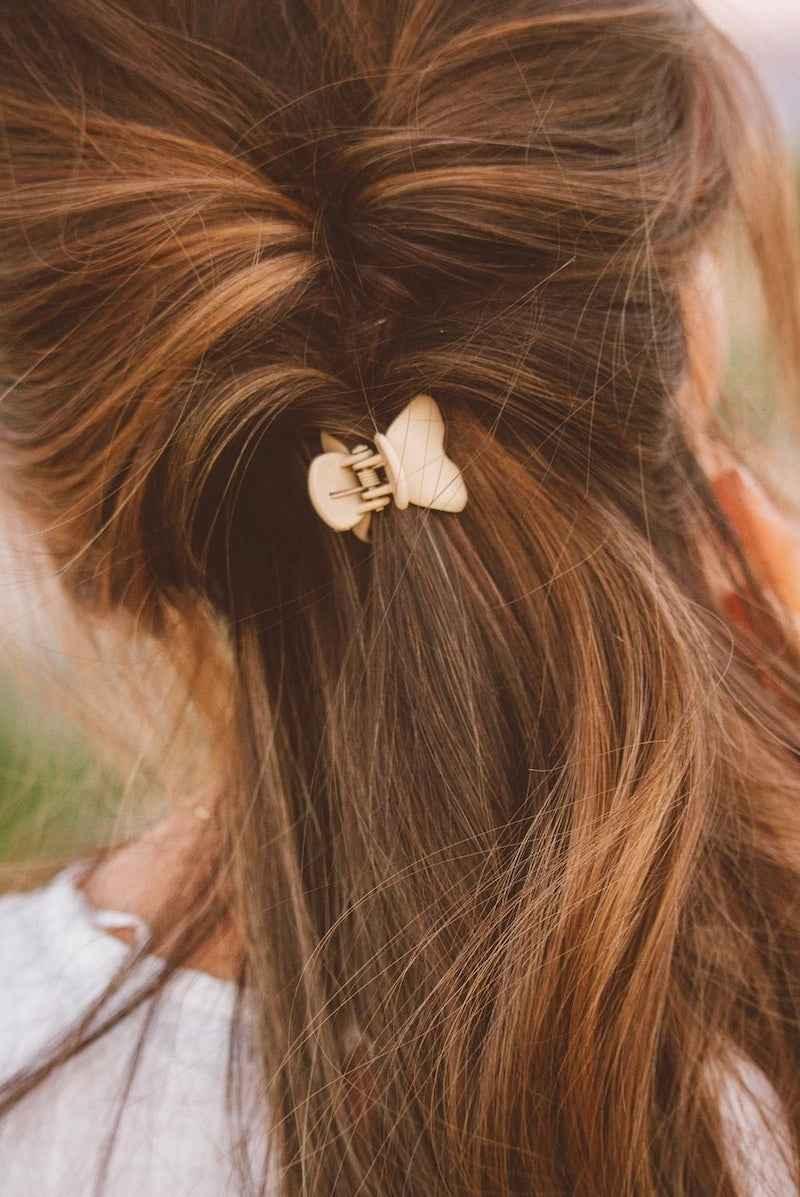Woman with brown hair styled in a claw clip from Love Classic, outdoor setting