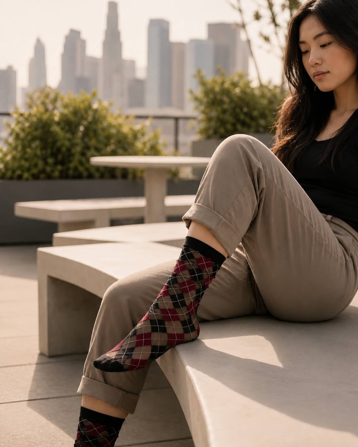 Sheer Argyle Crew Socks in black, red, and beige with a bold diamond pattern, worn with cropped trousers and leather loafers in an urban outdoor setting, emphasizing the breathable mesh and vibrant argyle design.
