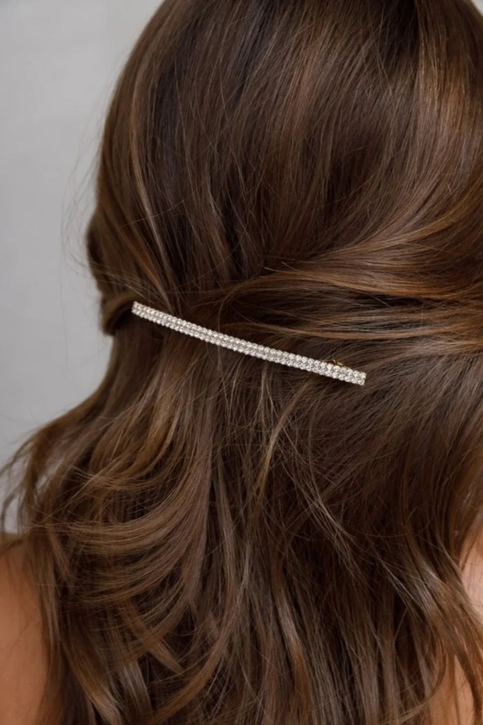 Brown wavy hair styled with a rhinestone hair clip, classic and elegant accessory from Love Classic