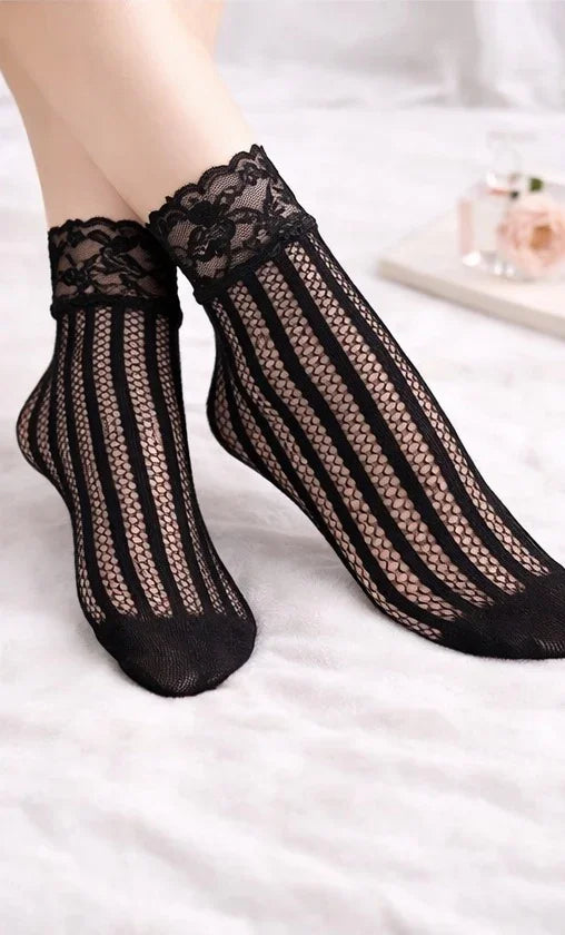 Black floral lace vertical stripe fishnet ankle socks worn with lace cuff detail, styled on feet against a soft neutral background.