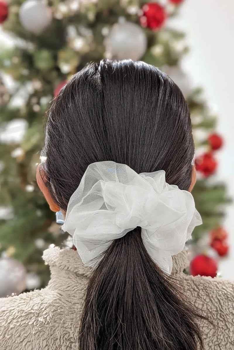 White organza scrunchie in dark hair, festive background, Love Classic high quality accessory