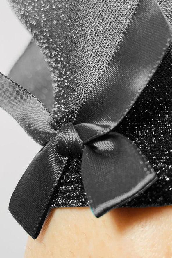 Close-up of a shiny black fabric with a satin bow, Love Classic high quality style detail.