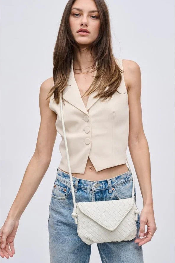 Woman wearing cream vest, jeans, and woven crossbody bag, Love Classic high quality style