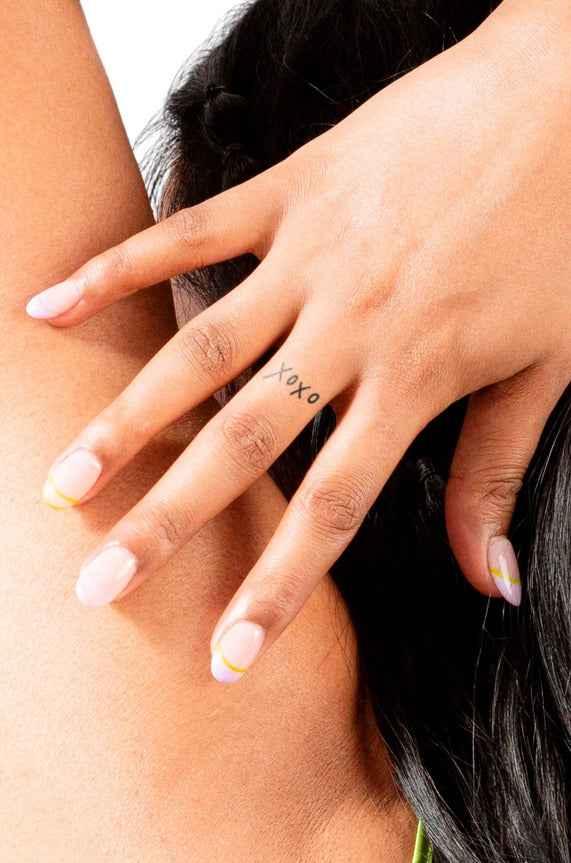 Hand with pastel French manicure and xoxo tattoo, Love Classic high quality style