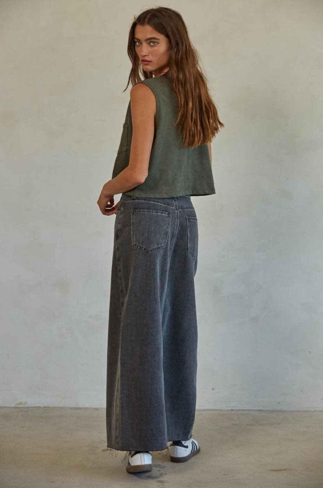 Woman in green pocket tank and wide-leg jeans, Love Classic fashion, neutral background
