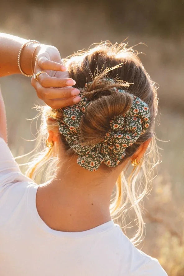Woman wearing a floral green hair scrunchie and gold earrings outdoors, Love Classic style