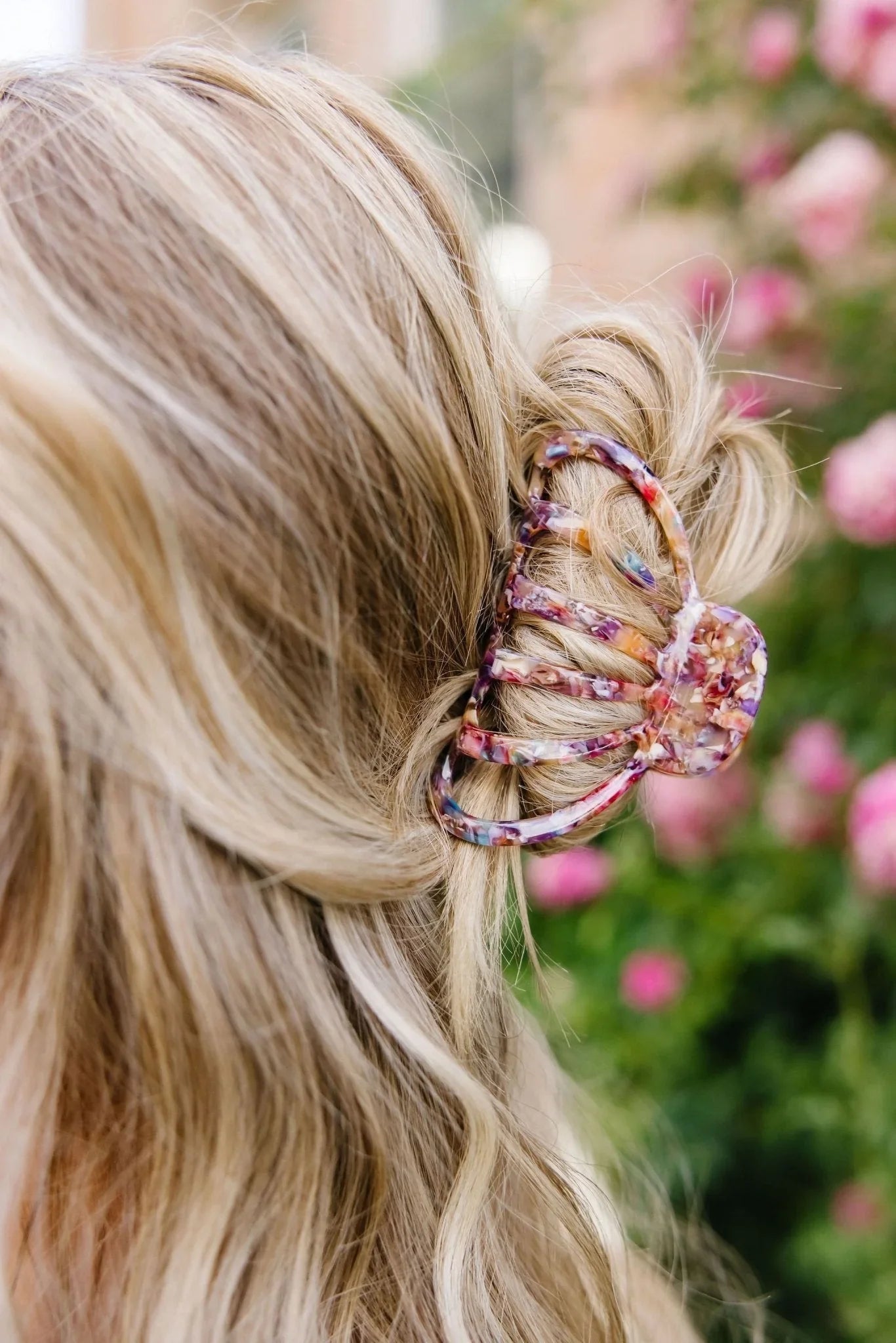 Blonde hair styled with multicolor claw clip, floral background, Love Classic accessory