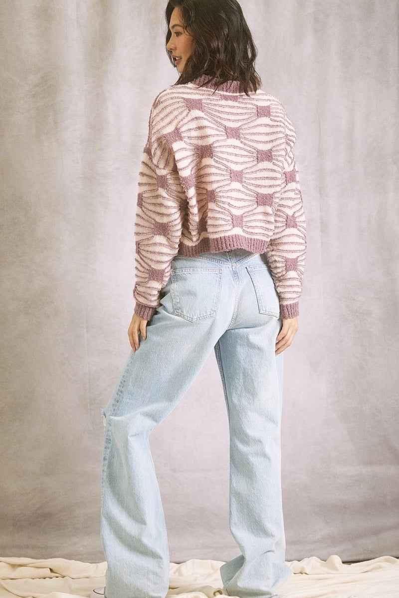 Woman wearing a pink patterned sweater and light blue jeans, Love Classic fashion style
