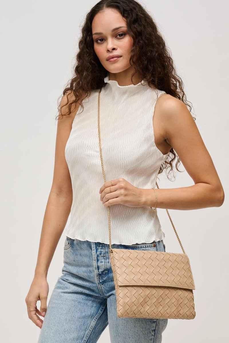 Woman in white sleeveless blouse and jeans holding a beige woven crossbody bag, Love Classic style