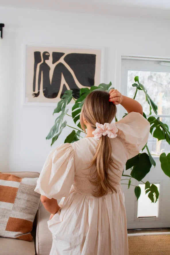 Woman in puff sleeve dress with hair scrunchie, standing indoors by plant, Love Classic style