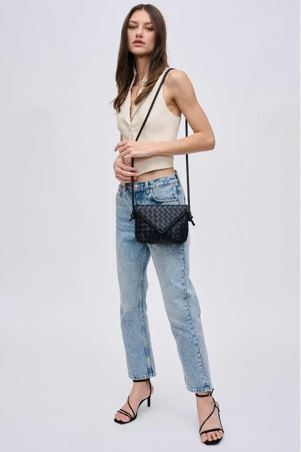 Woman in sleeveless beige top and jeans with black quilted crossbody bag and heels, Love Classic style