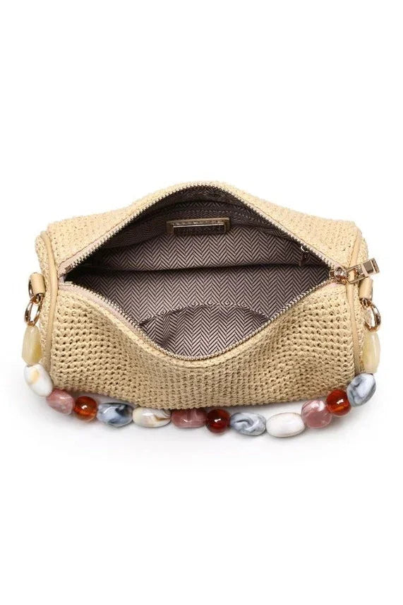 Interior view of the natural Rachel Straw Clutch displaying a neatly sized compartment that fits a phone, cards, and daily must-haves.