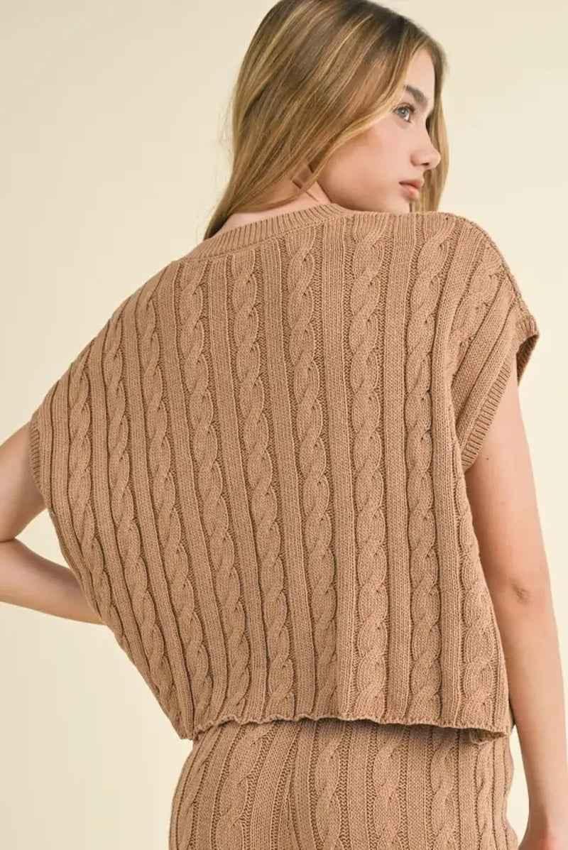 Woman wearing a tan cable knit sleeveless sweater set from Love Classic