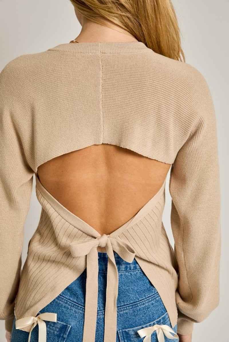 Beige open-back sweater with tie detail from Love Classic, paired with blue jeans
