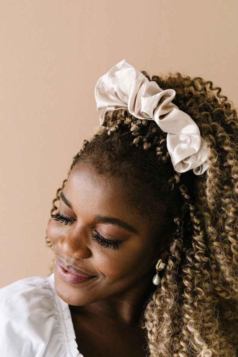 Woman with curly hair wearing a large satin scrunchie, showcasing Love Classic hair accessory style