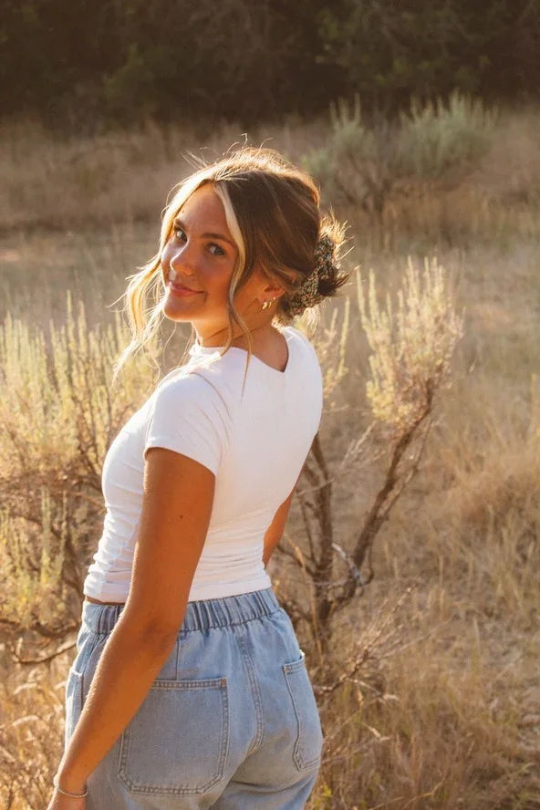 Woman in white t-shirt and blue jeans smiling outdoors, Love Classic fashion style