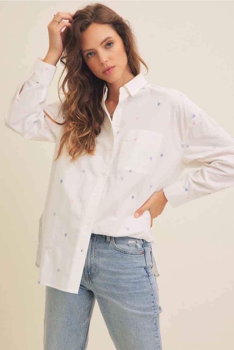 Woman wearing a white button-up shirt with small pastel heart prints and light blue jeans, Love Classic style