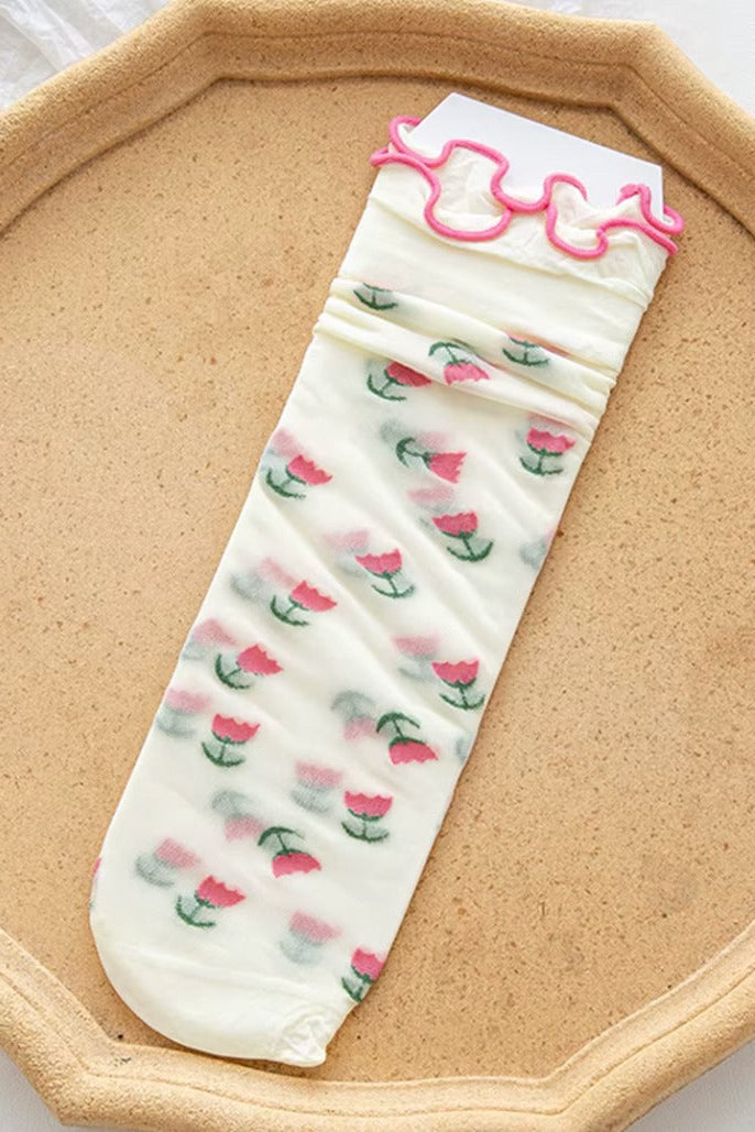 Sheer mesh crew socks with a pink tulips pattern and a soft lettuce-edge cuff on a neutral background.