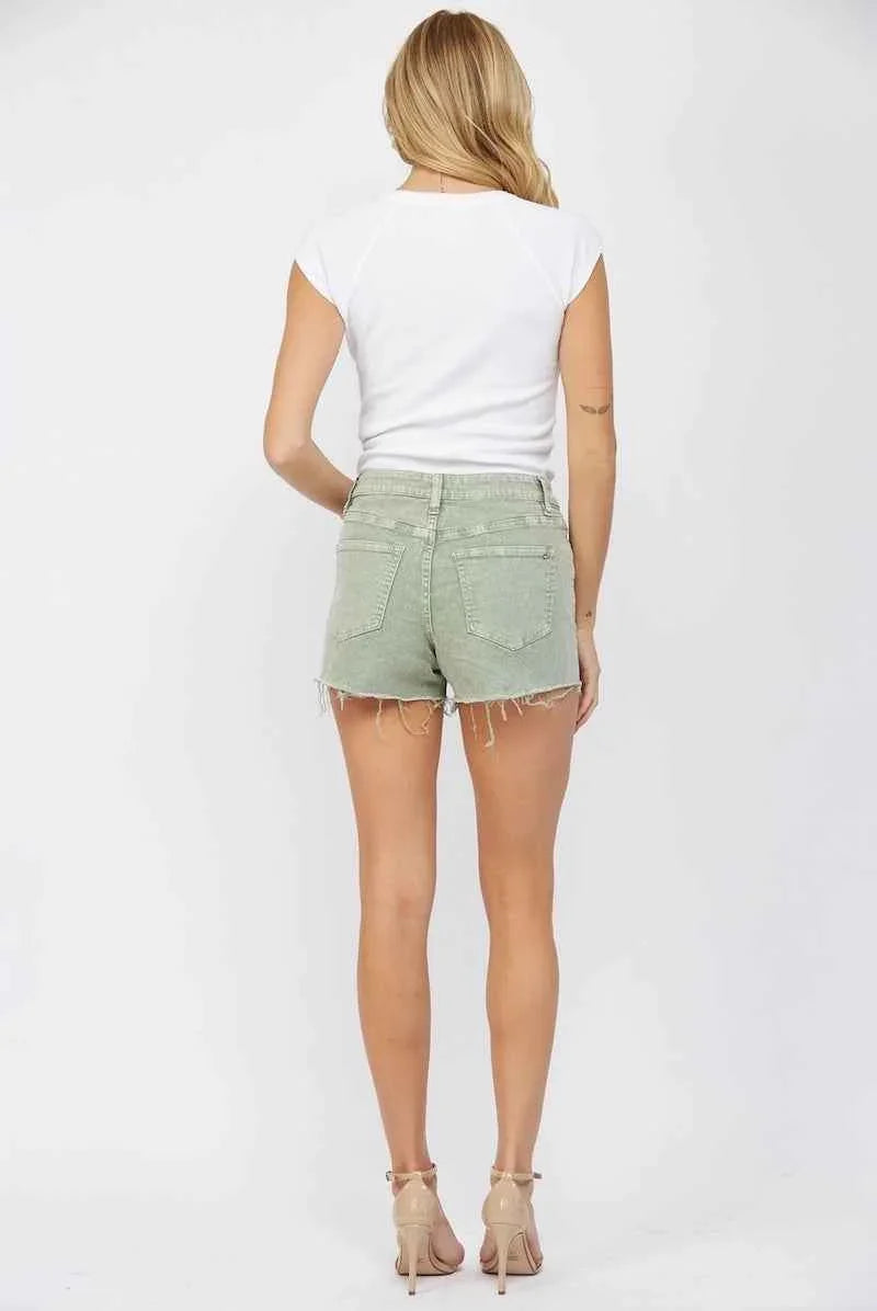 Woman modeling sage green denim shorts with frayed hems and a white tee for Love Classic