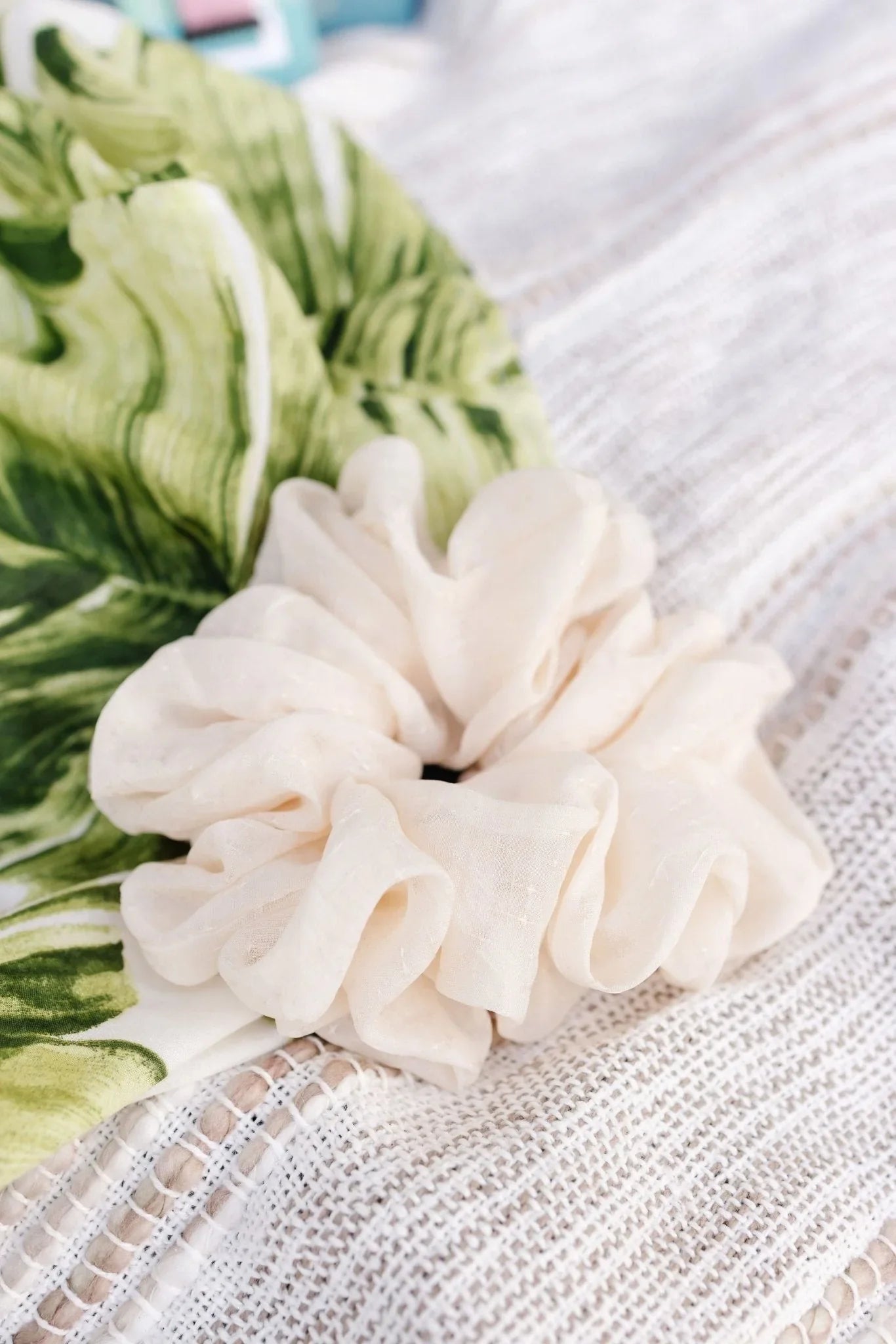 Cream jumbo scrunchie on textured white fabric, Love Classic hair accessory