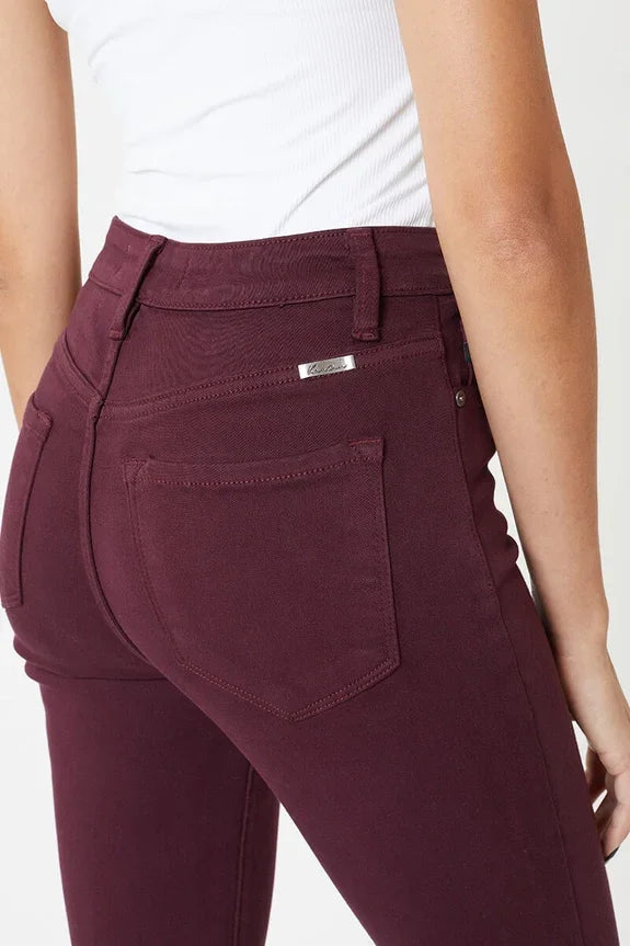 Woman wearing burgundy skinny jeans from Love Classic and white ribbed top