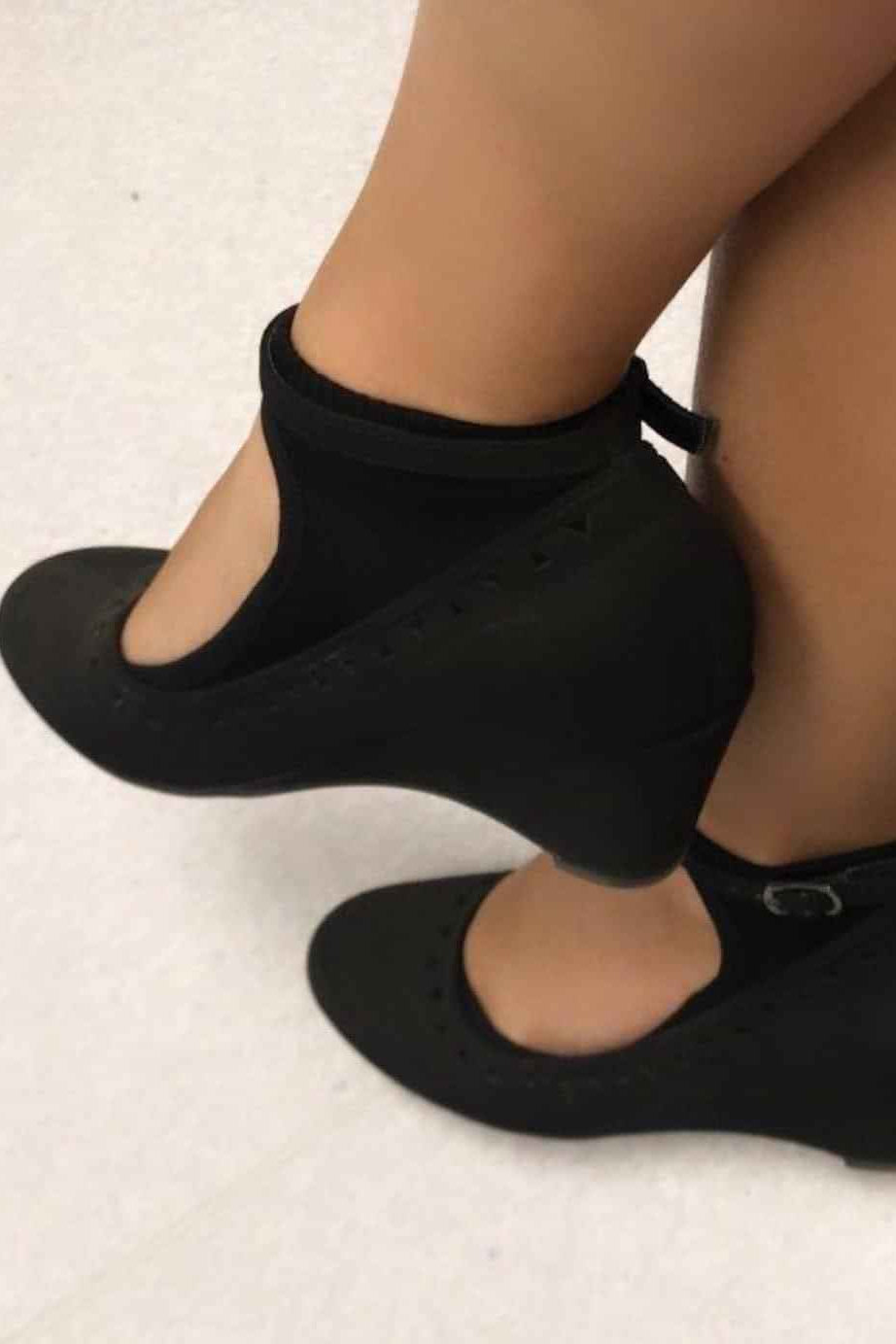 “Black ballet-cut no-show sock on a model’s foot, featuring a low curved opening and soft knit material.”