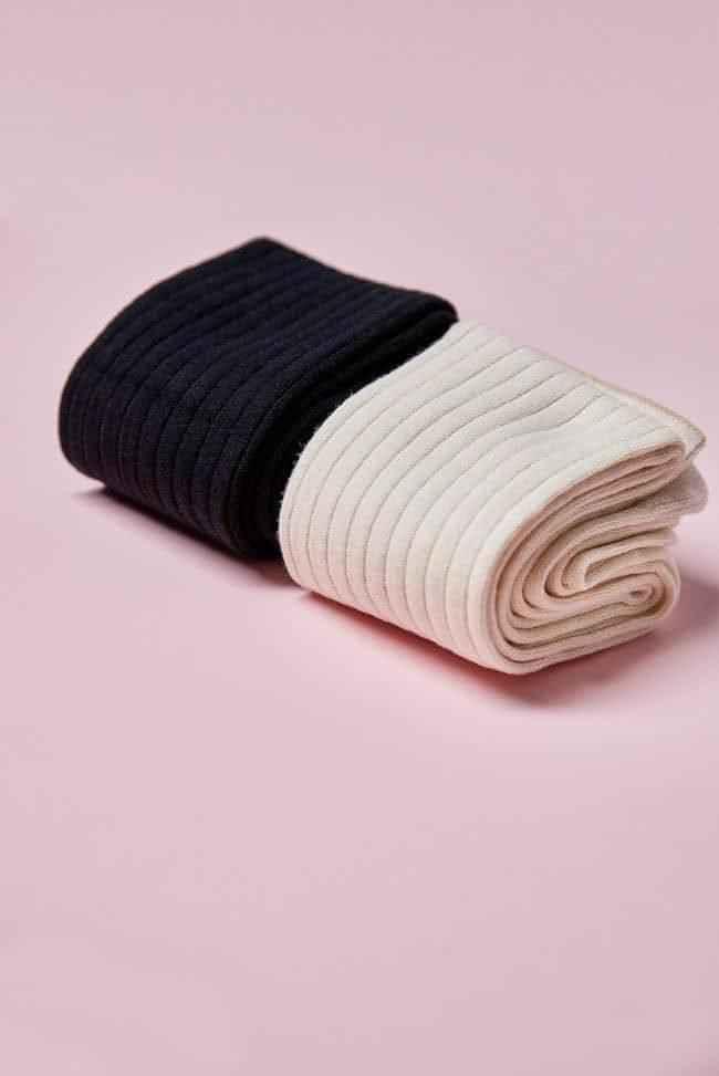 Black and cream ribbed socks from Love Classic on a pink background