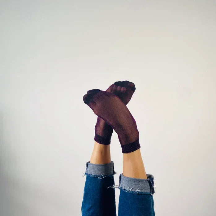 Sheer purple socks styled with rolled-up jeans on crossed legs, Love Classic fashion