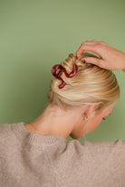 Model holding hair up with Swirl Claw Clip, showcasing the stunning design and perfect color for the season.