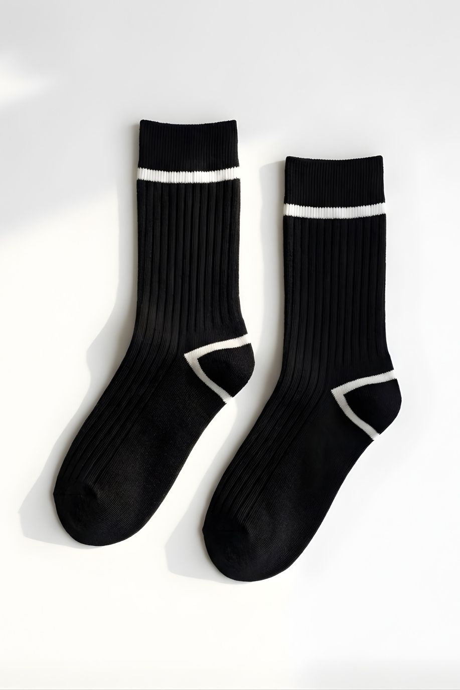 Classic Ribbed Crew Socks with Contrast Trim, black ribbed crew socks with white stripe detail at the cuff and geometric contrast at the heel, displayed flat against a clean neutral background to highlight texture and design.