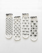 4-Pack Geo Print Ruffle Edge Sheer Socks featuring four unique transparent sock styles with polka dot, heart, bow, and floral-inspired geometric patterns, finished with contrasting ruffle-edge cuffs and displayed on a clean white background to showcase variety, lightweight construction, and coordinated styling.