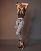 Woman modeling high-waisted acid wash jeans and black crop top, Love Classic fashion style