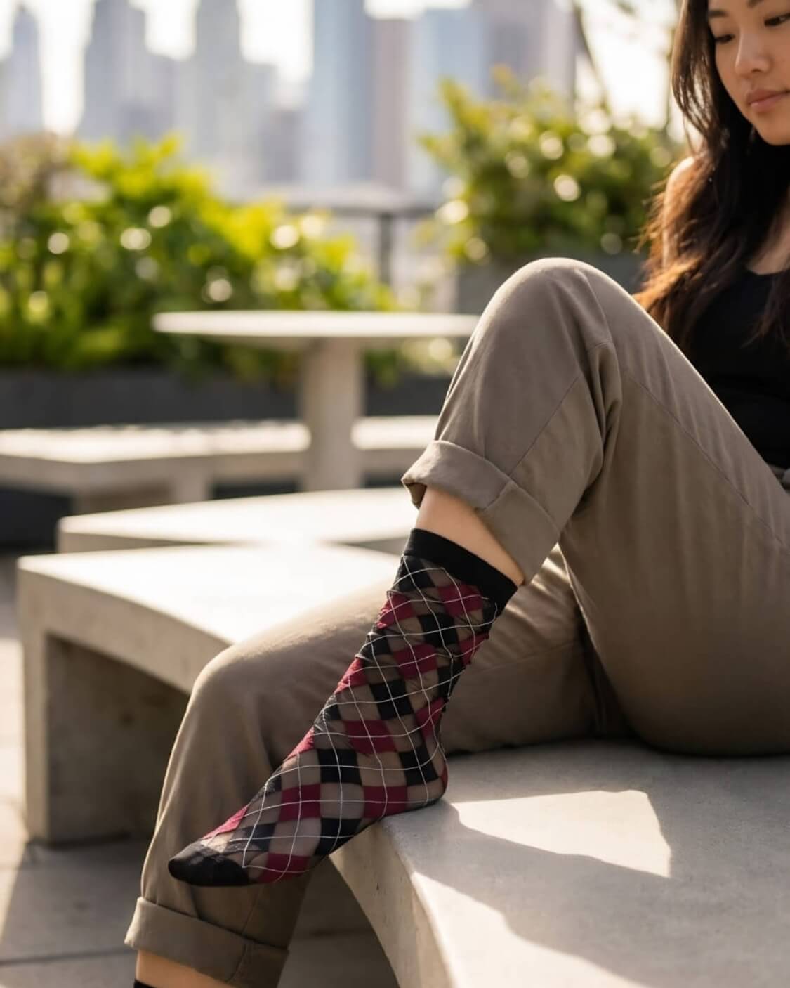 Sheer Argyle Crew Socks in black, red, and beige with a bold diamond pattern, worn with cropped trousers and leather loafers in an urban outdoor setting, emphasizing the breathable mesh and vibrant argyle design.
