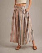 Multi-Stripe Pleated Front Wide-Leg Pants featuring a flowing wide-leg silhouette with soft vertical stripe detailing and front pleats, styled with flat slide sandals in a neutral studio setting, highlighting the relaxed drape and comfortable everyday movement.